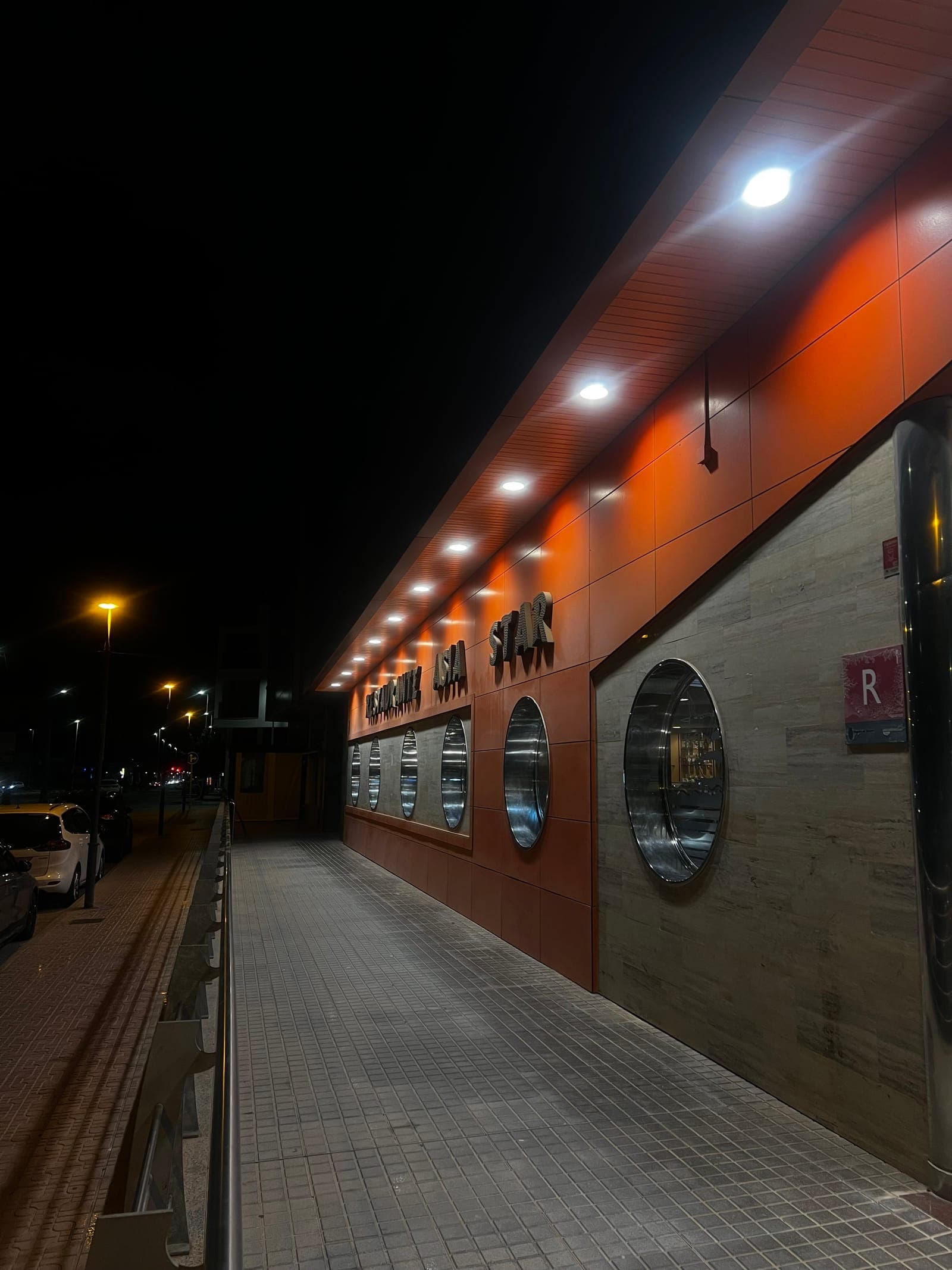 The illuminated orange facade and Restaurante Asia Star sign at night